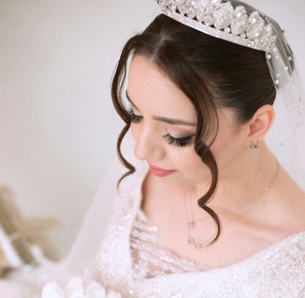A beautiful bride in an embellished gown holding a white bouquet, symbolizing elegance and purity.